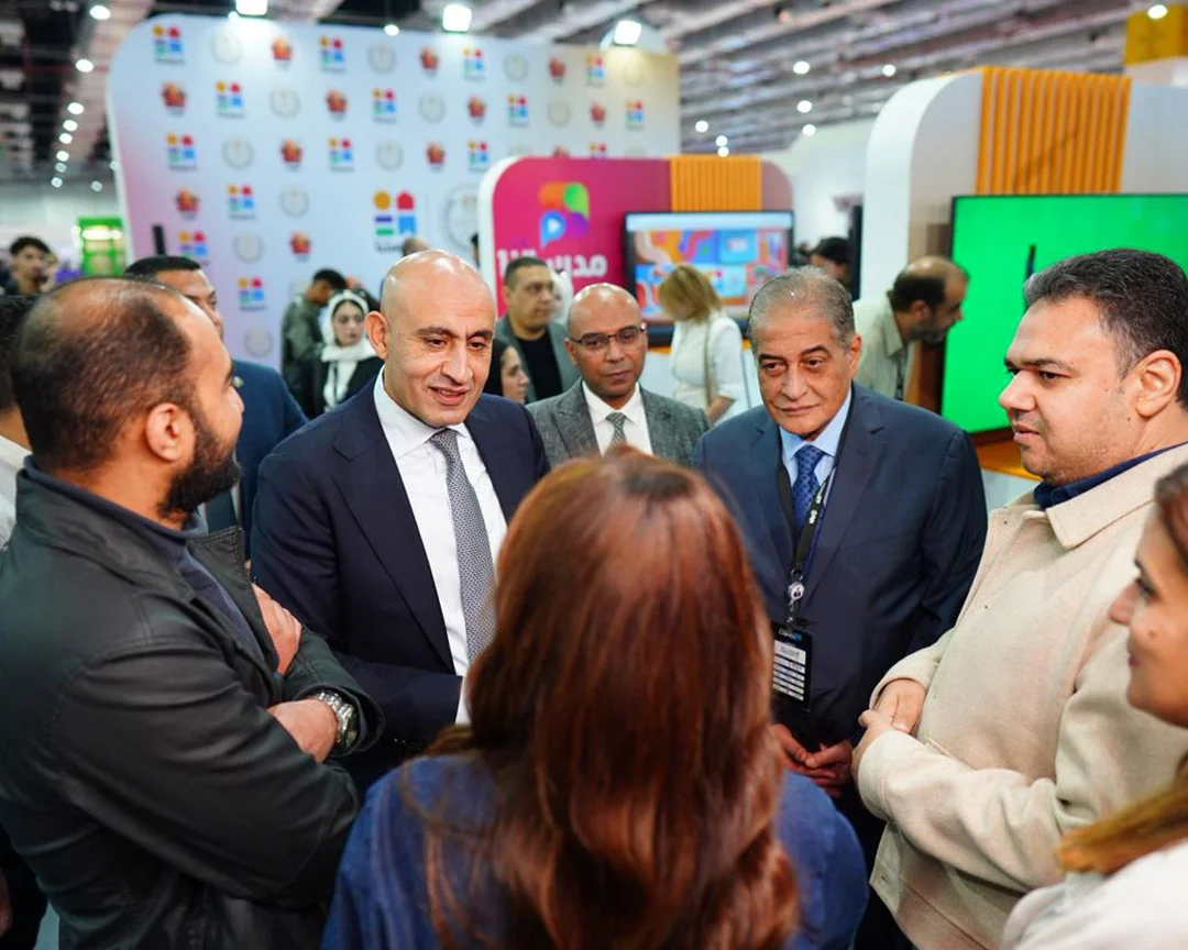 Visitors in conversation at an exhibition stand, AIDC² Expo 2025
