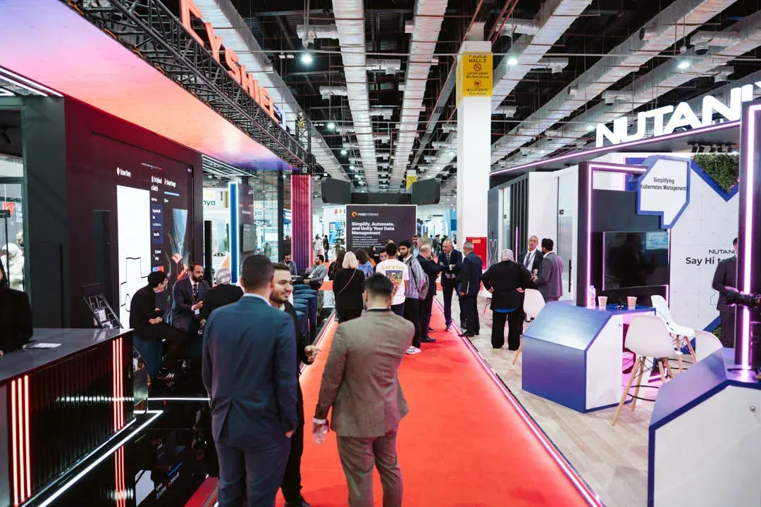 A bustling trade show aisle filled with energy, conversations, and vibrant tech displays.